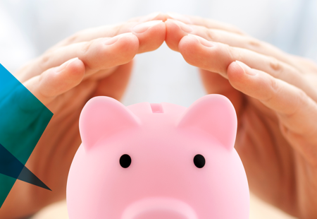 Photograph of a piggy bank with someone's hands arched above it as if they were sheltering it